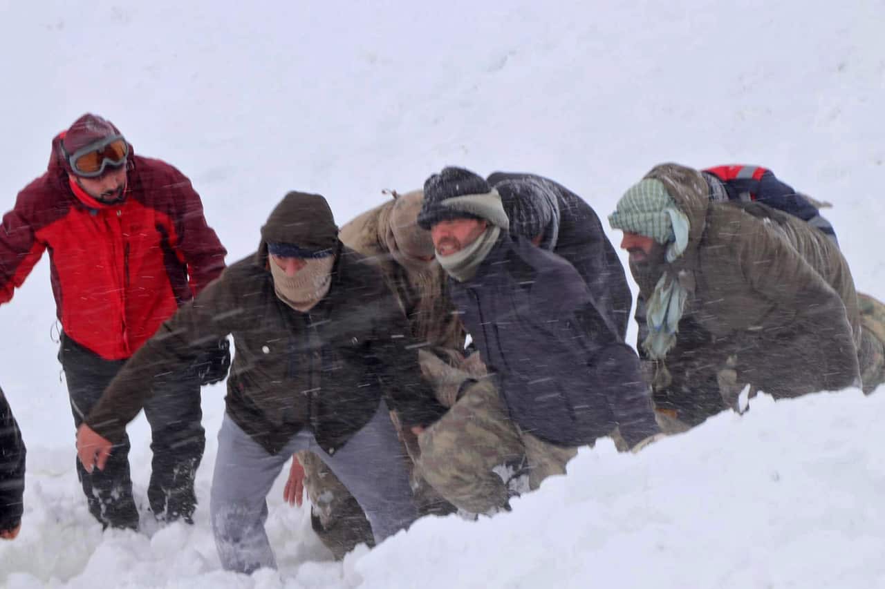 Turkish soldiers and rescue workers search for people missing after a double avalanche.