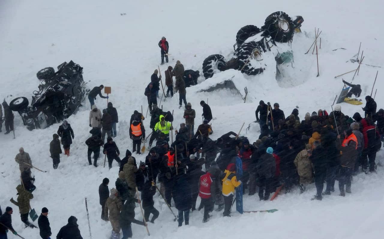 Emergency service members work in the snow around overturned vehicles, near the town of Bahcesaray, Van province, eastern Turkey.