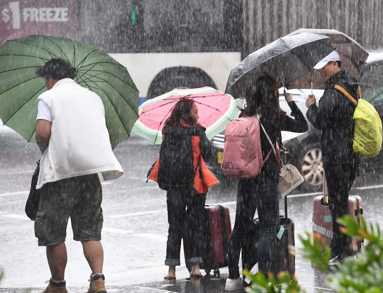 Pedestrians seek shelter from the rain in Sydney.