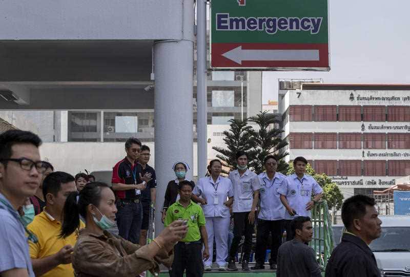 Medical staff wait outside a hospital emergency where victims of the mass shooting were being treated inside 