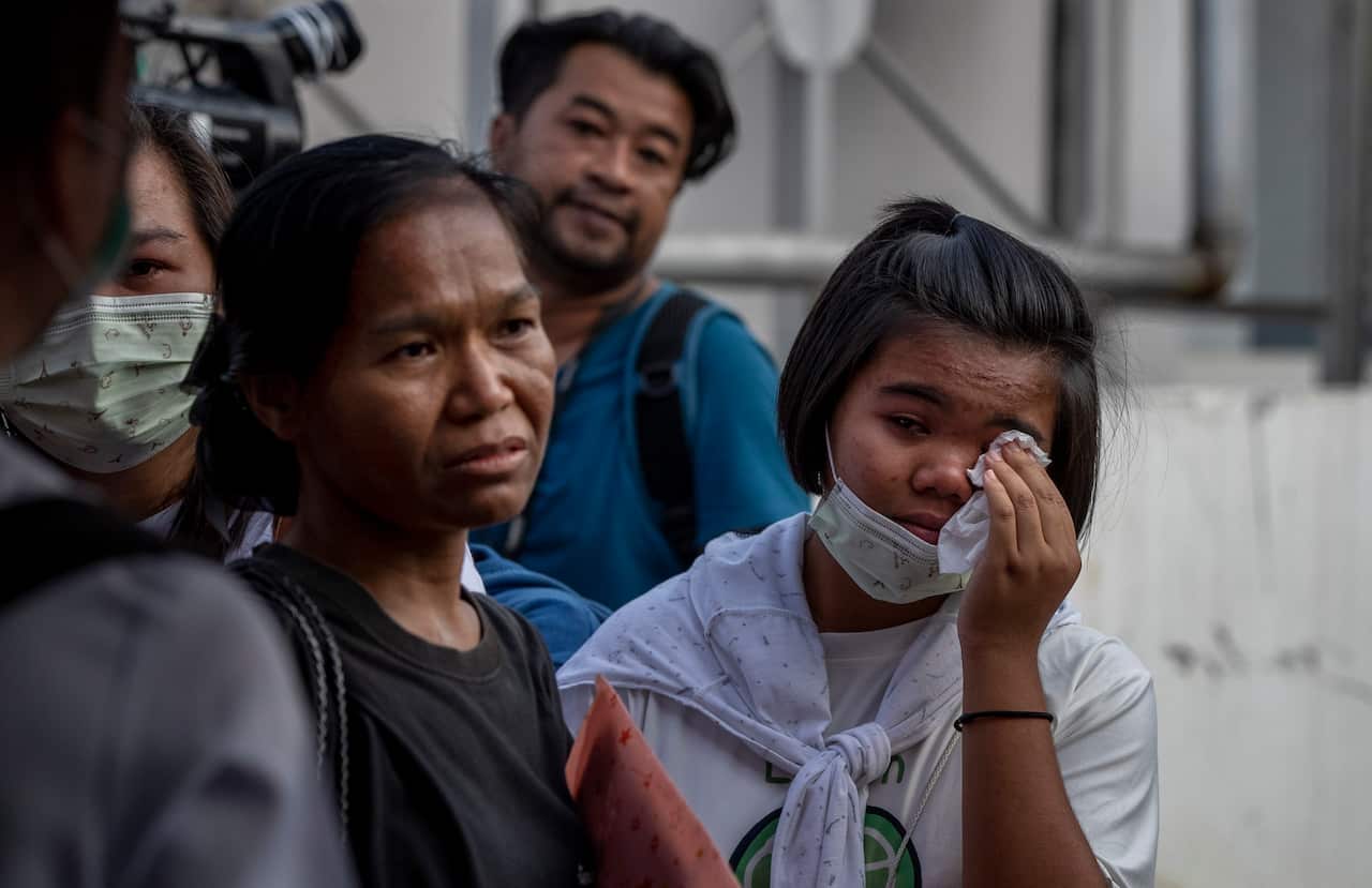 Relatives of mass shooting fatalities wait outside a morgue at Korat, Nakhon Ratchasima, Thailand, 9 February, 2020. 