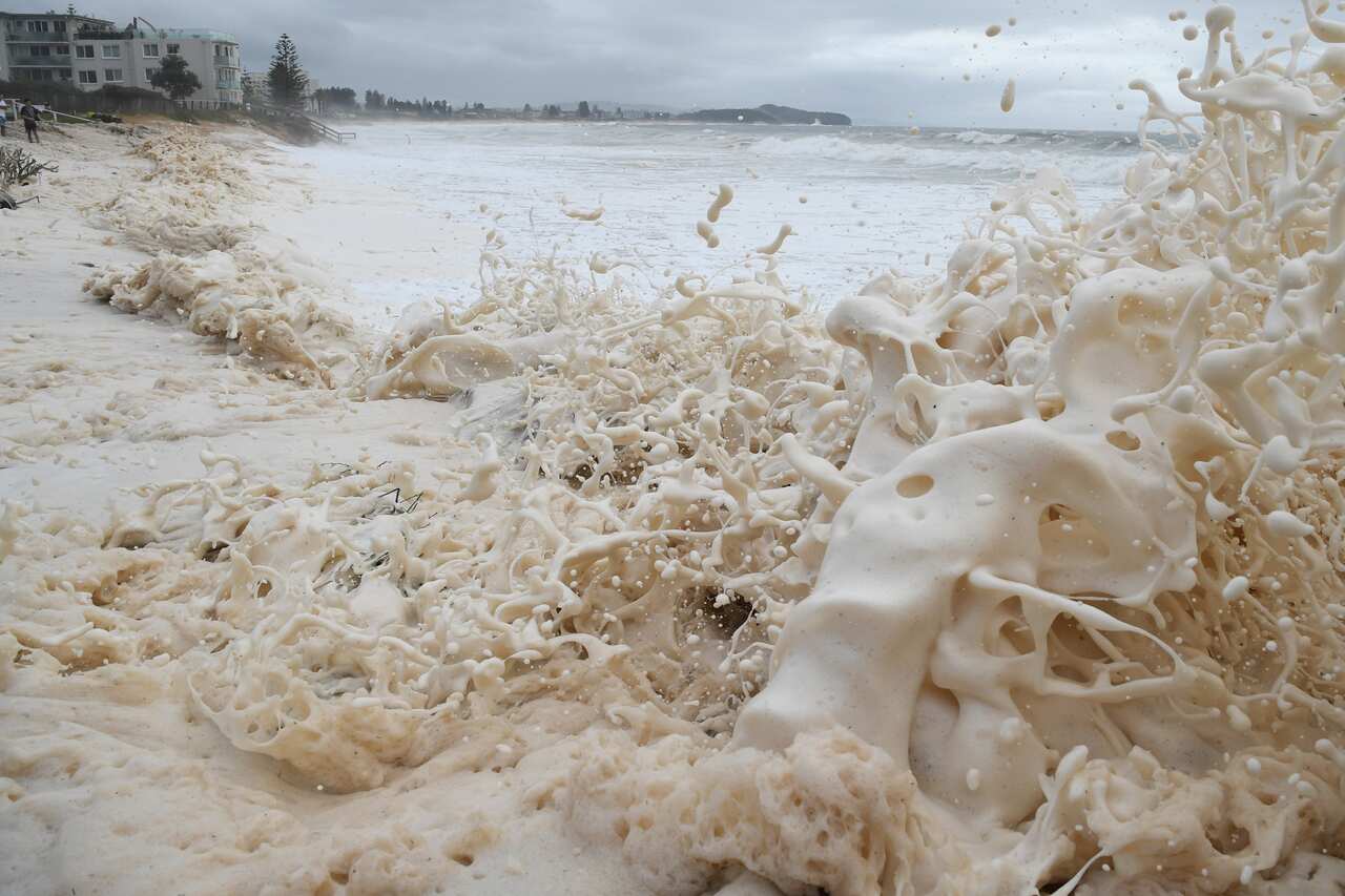 Sea foam brought by waves approaches on beach front houses after heavy rain and storms at Collaroy in Sydney's Northern Beaches.