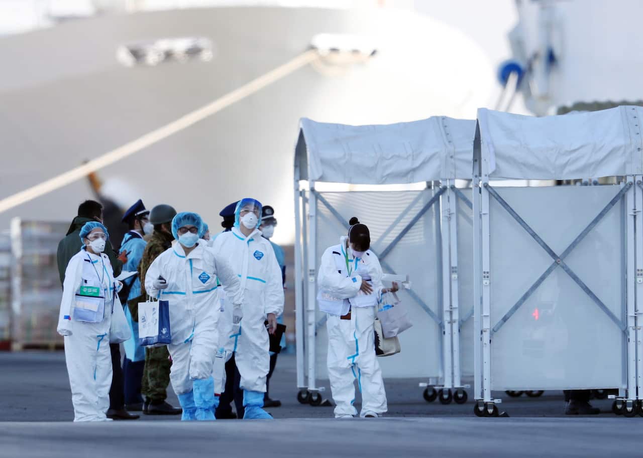Staff members wearing protective gear prepare to enter the Diamond Princess cruise ship in Yokohama,  Japan, 10 February 2020. 