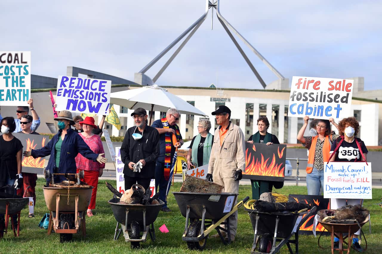 Bushfire survivors use burnt debris from the recent bushfires to create a symbolic trail of destruction outside Parliament House.