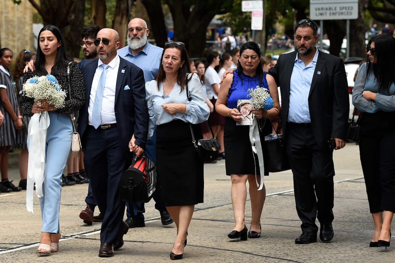 Family members are seen behind the hearse.
