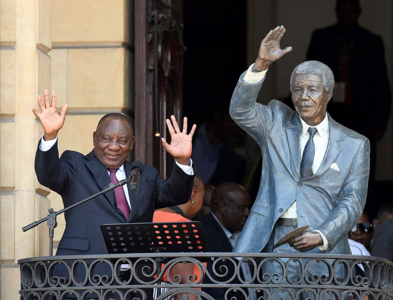 South African President Cyril Ramaphosa, left, next to a sculpture of former President Nelson Mandela.