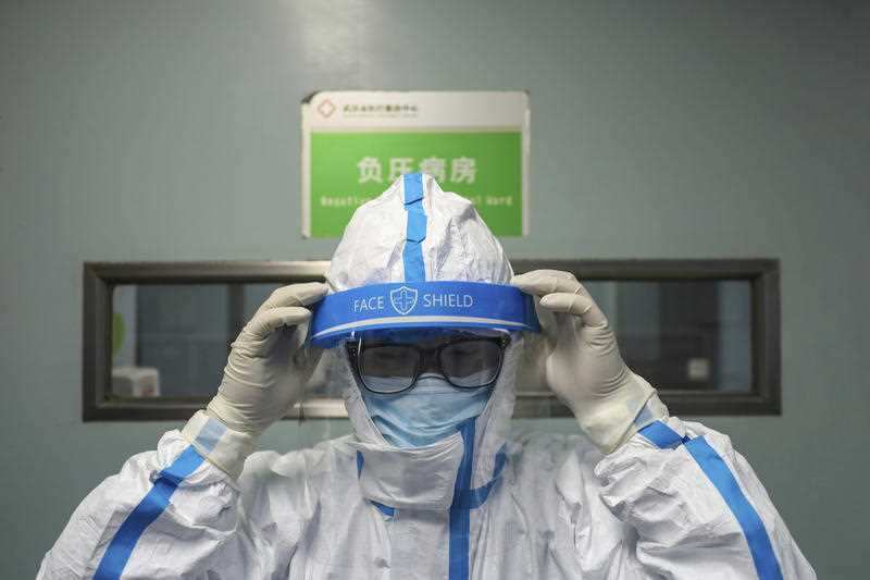 A doctor puts on an isolation outfit before entering the negative-pressure isolation ward in Jinyintan Hospital