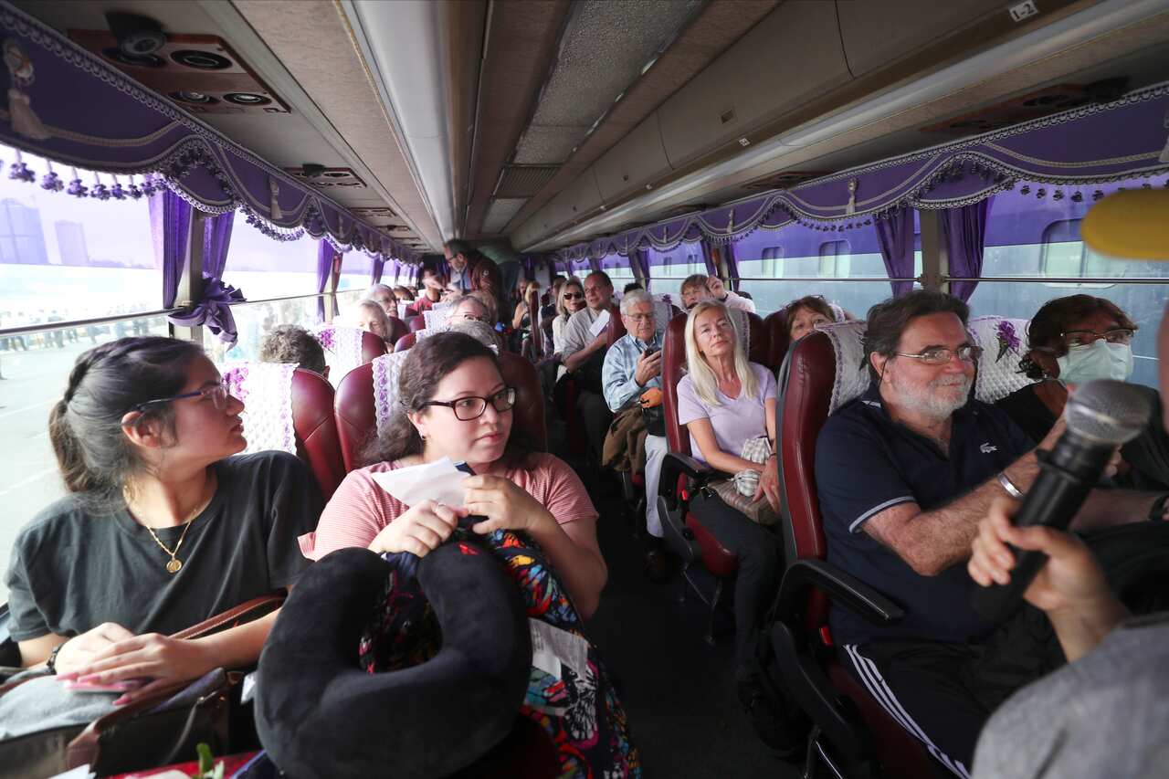 Passengers from the MS Westerdam, owned by Holland America Line, sit on a bus at the port of Sihanoukville, Cambodia, Friday, 14 February, 2020. 