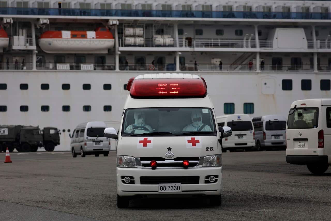 Medical workers wearing protective suits leave after tending to passengers on the quarantined Diamond Princess.