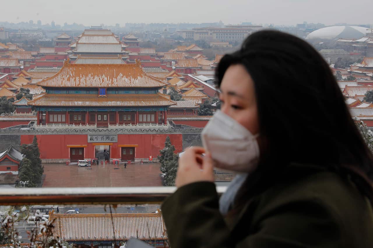 A woman wears a protective mask at Jingshan Park in Beijing.