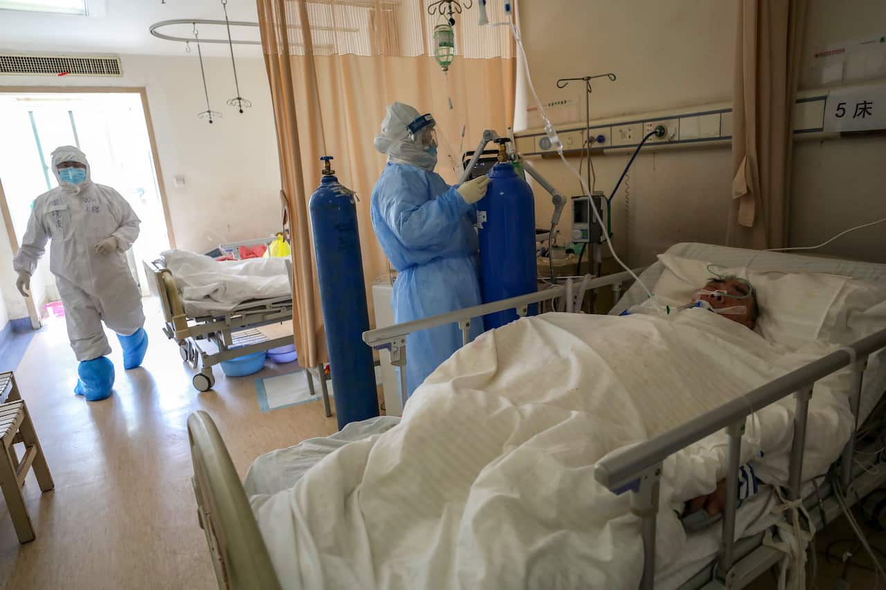 Medical workers provide treatment to a new coronavirus patient at a hospital in Wuhan in central China's Hubei province. 