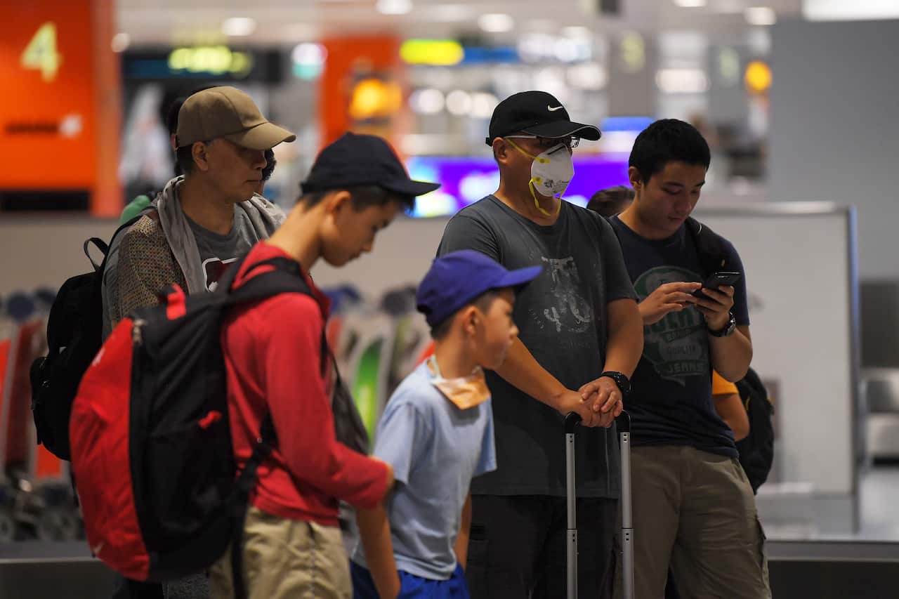 Travellers wait for their bags at Sydney airport
