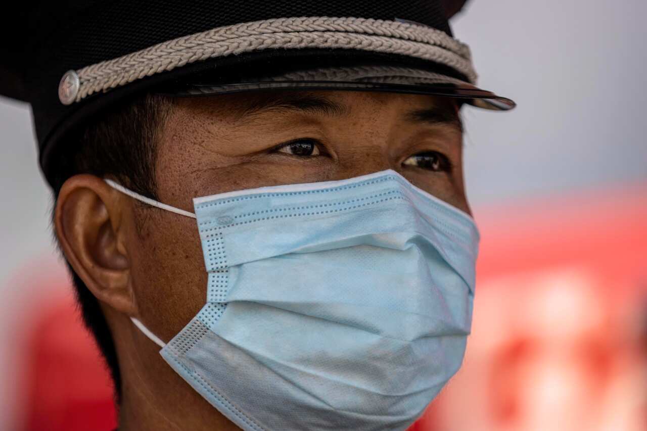 Police and medical workers stop vehicles on the highway road blockade for a health check in Guangzhou, China.
