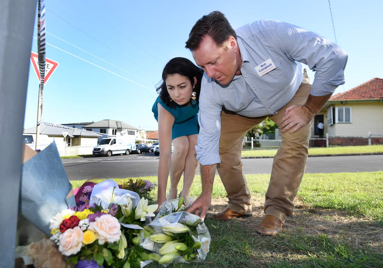 Federal member for Griffith Terri Butler and Labor's candidate for Brisbane City council Matt Campbell place flowers near the scene of the fatal car fire. 