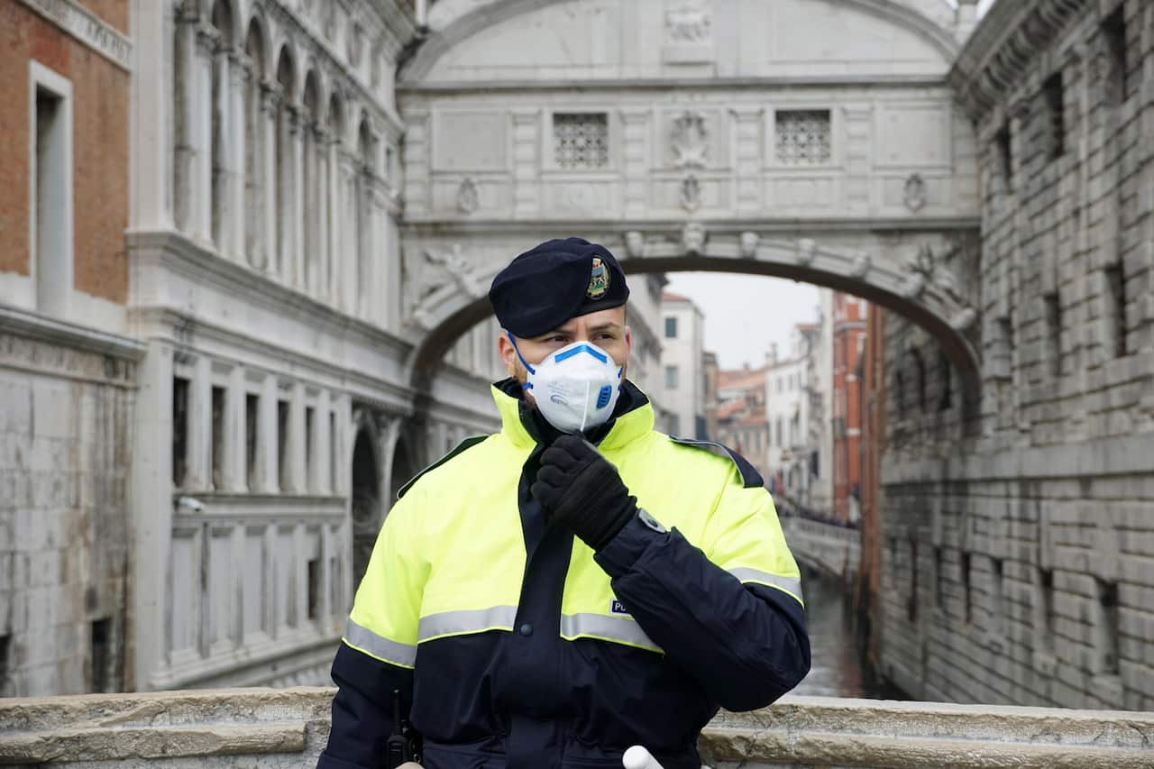 A local police officer wears a protective face mask during the Carnival in Venice, Italy, 23 February 2020. 