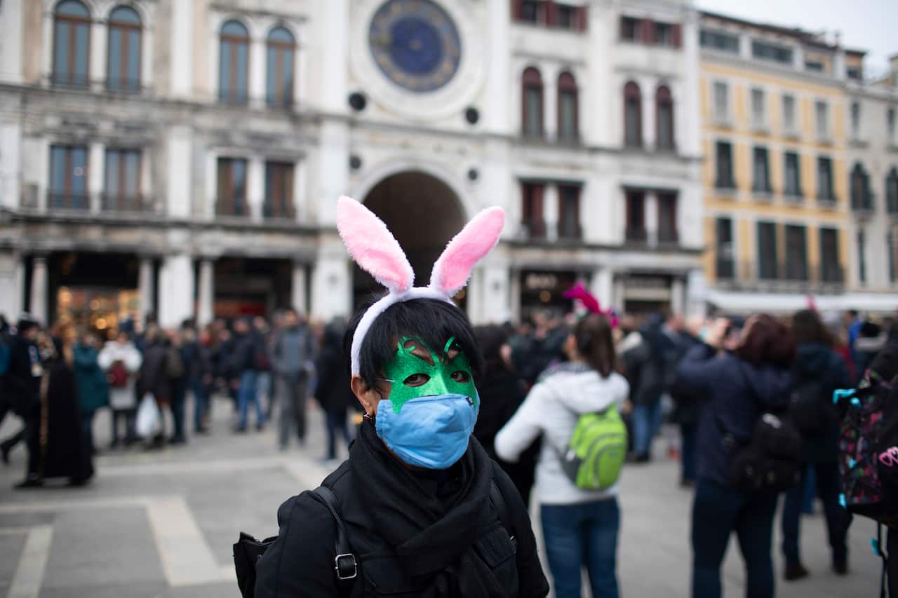 Tourists wear protective face masks during the Carnival in Venice The carnival has been cancelled over concerns of the spread of virus in northern Italy.