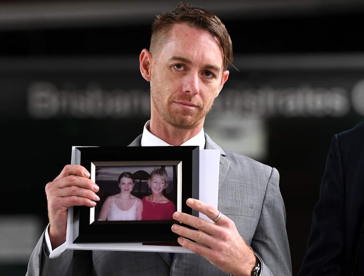 Michael Cooke, brother of Cindy Low, holds a picture of her as he leaves the Magistrates Court in Brisbane, Monday, 24 February, 2020.