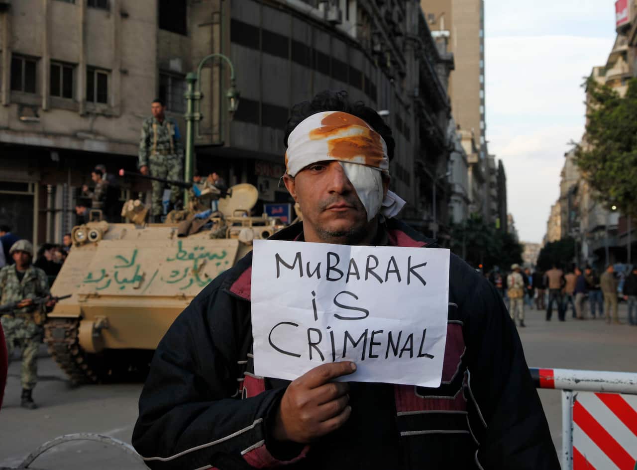 A wounded demonstrator carries a poster in Cairo.