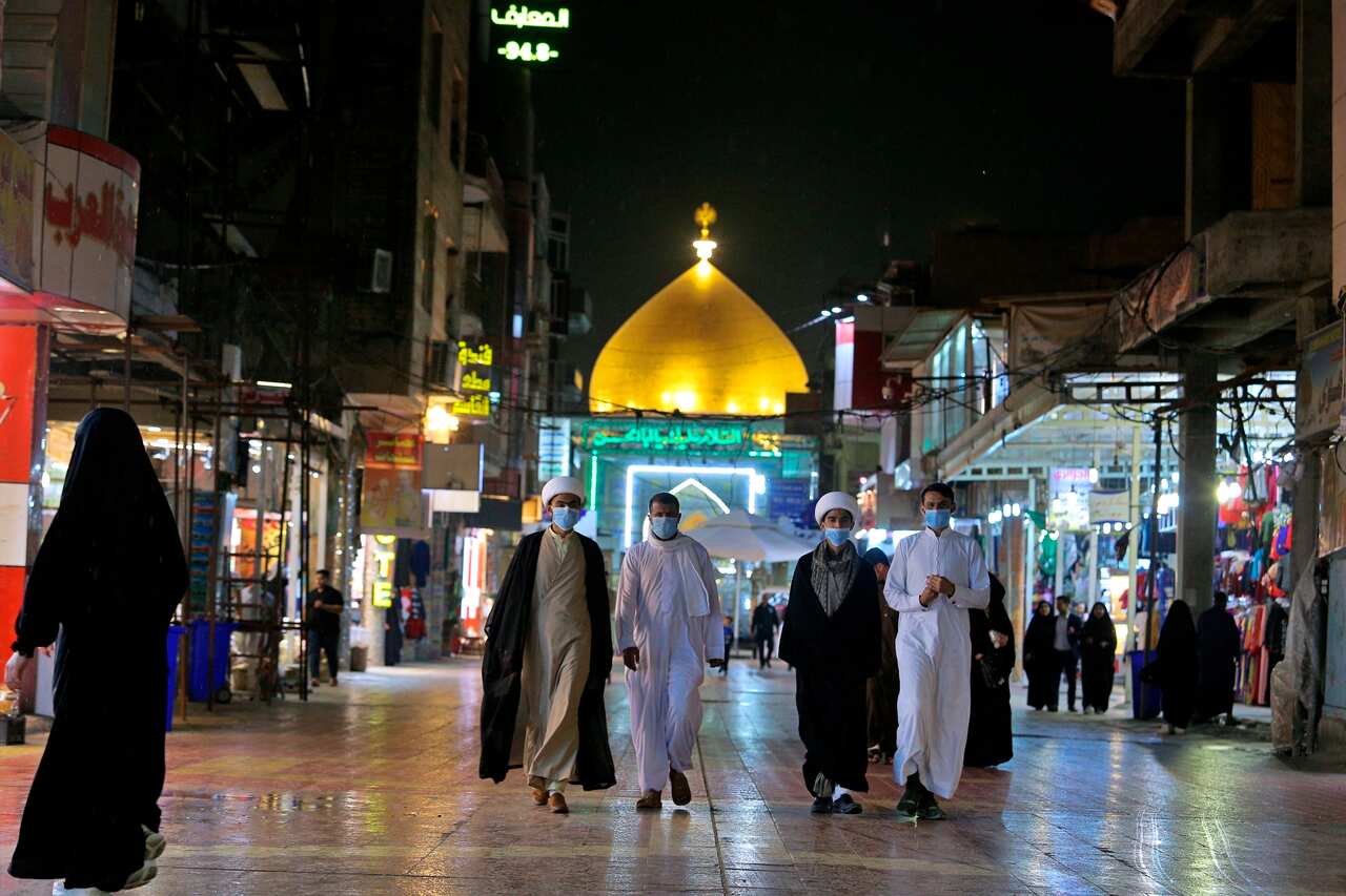 Shiite pilgrims wear masks outside the shrine of Imam Ali in Najaf, Iraq. 