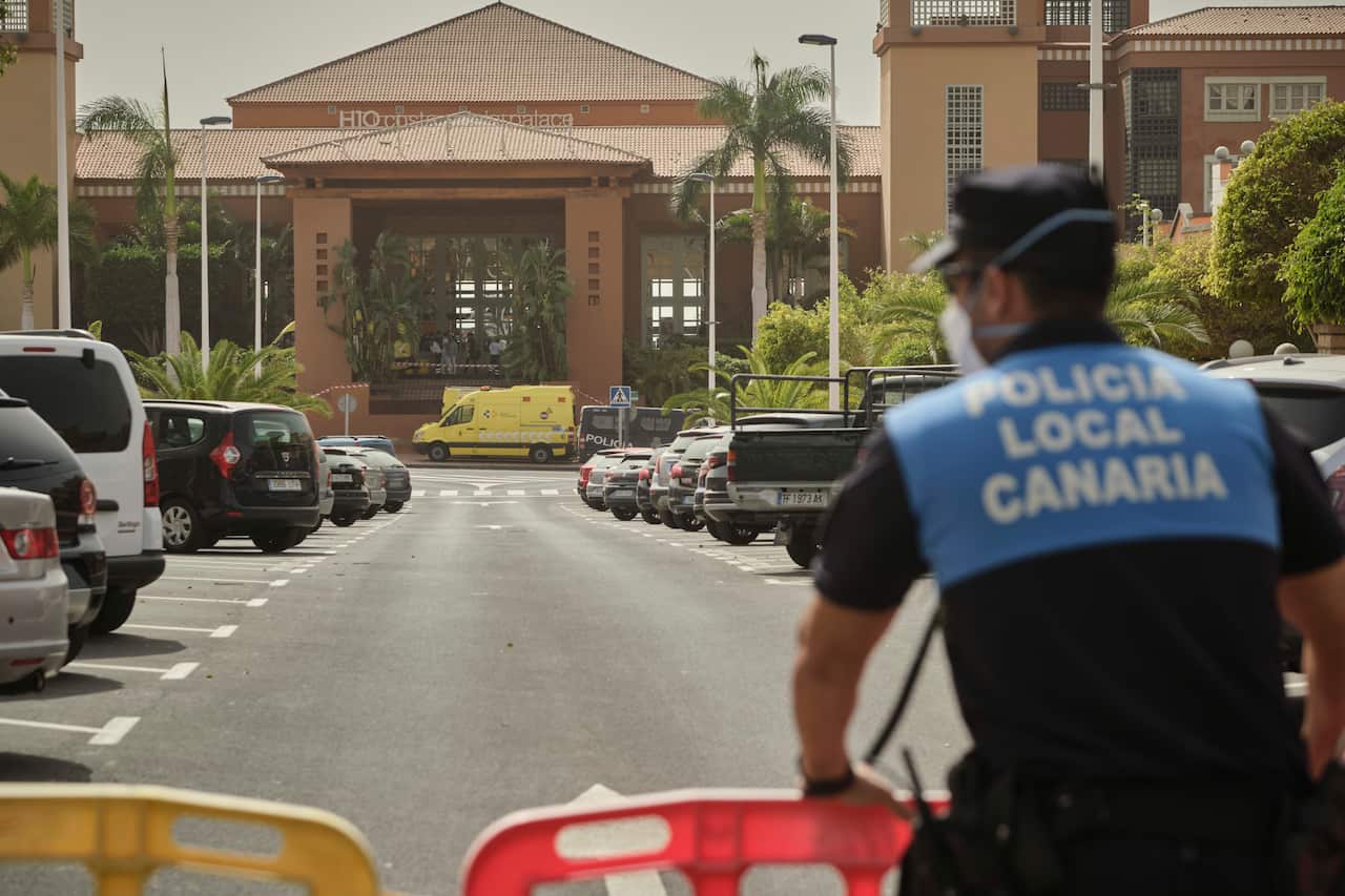 A police officer stands by a barrier in front of the H10 Costa Adeje Palace hotel where an ambulance is parked in Tenerife, Canary Island, Spain.