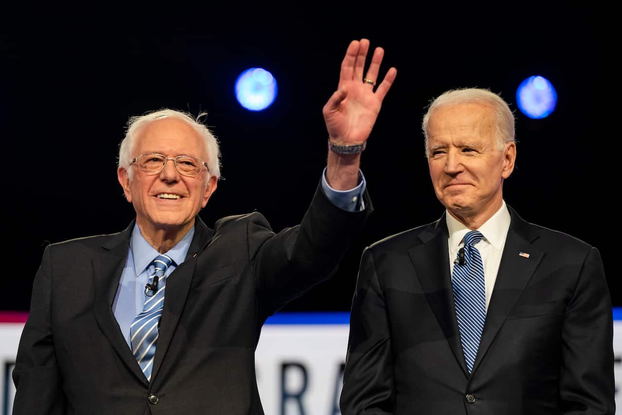 Democratic presidential candidates Bernie Sanders (L) and Joe Biden (R) stand on stage during the tenth Democratic presidential debate.