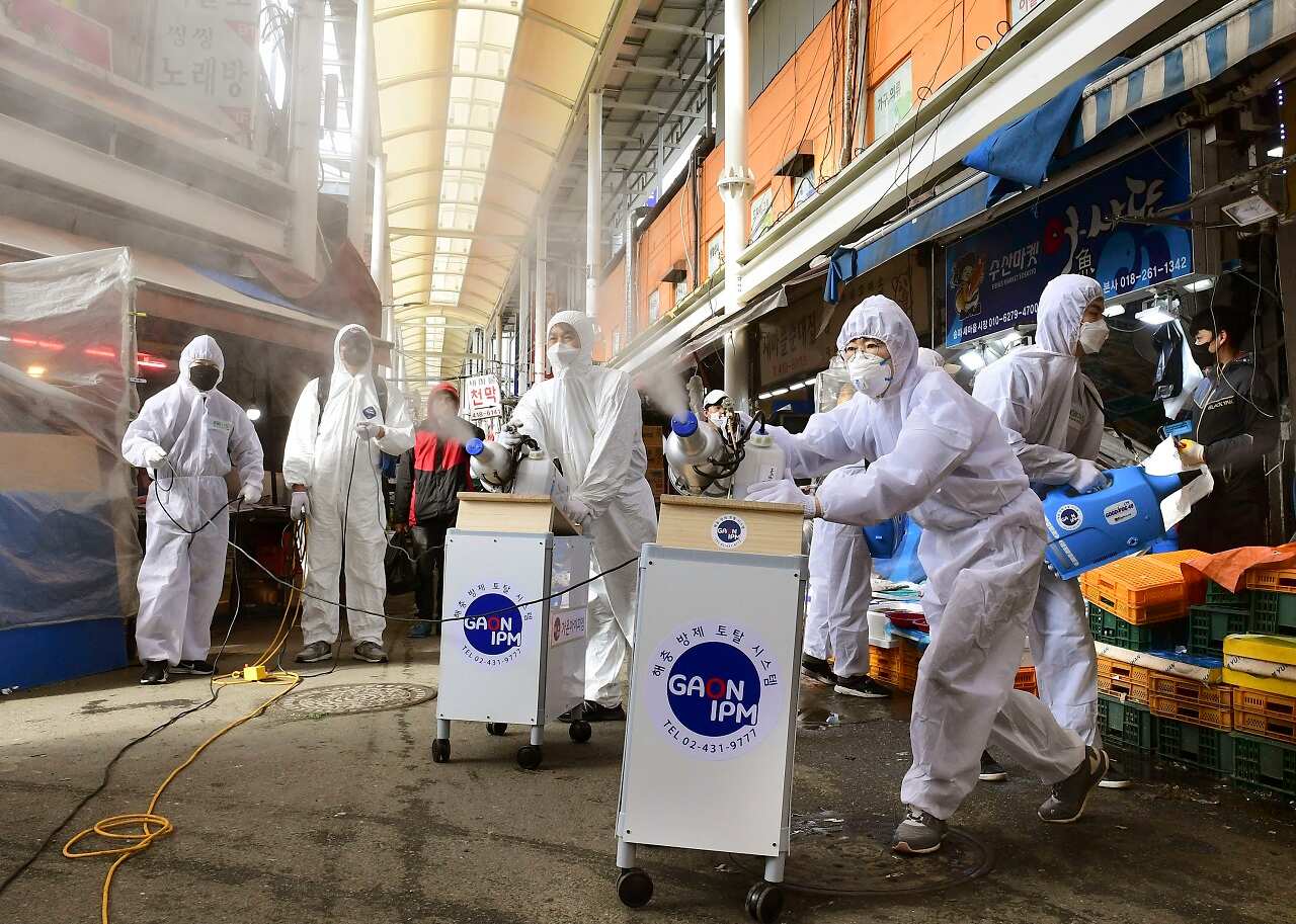 Officials disinfect a market in Seoul on Wednesday.