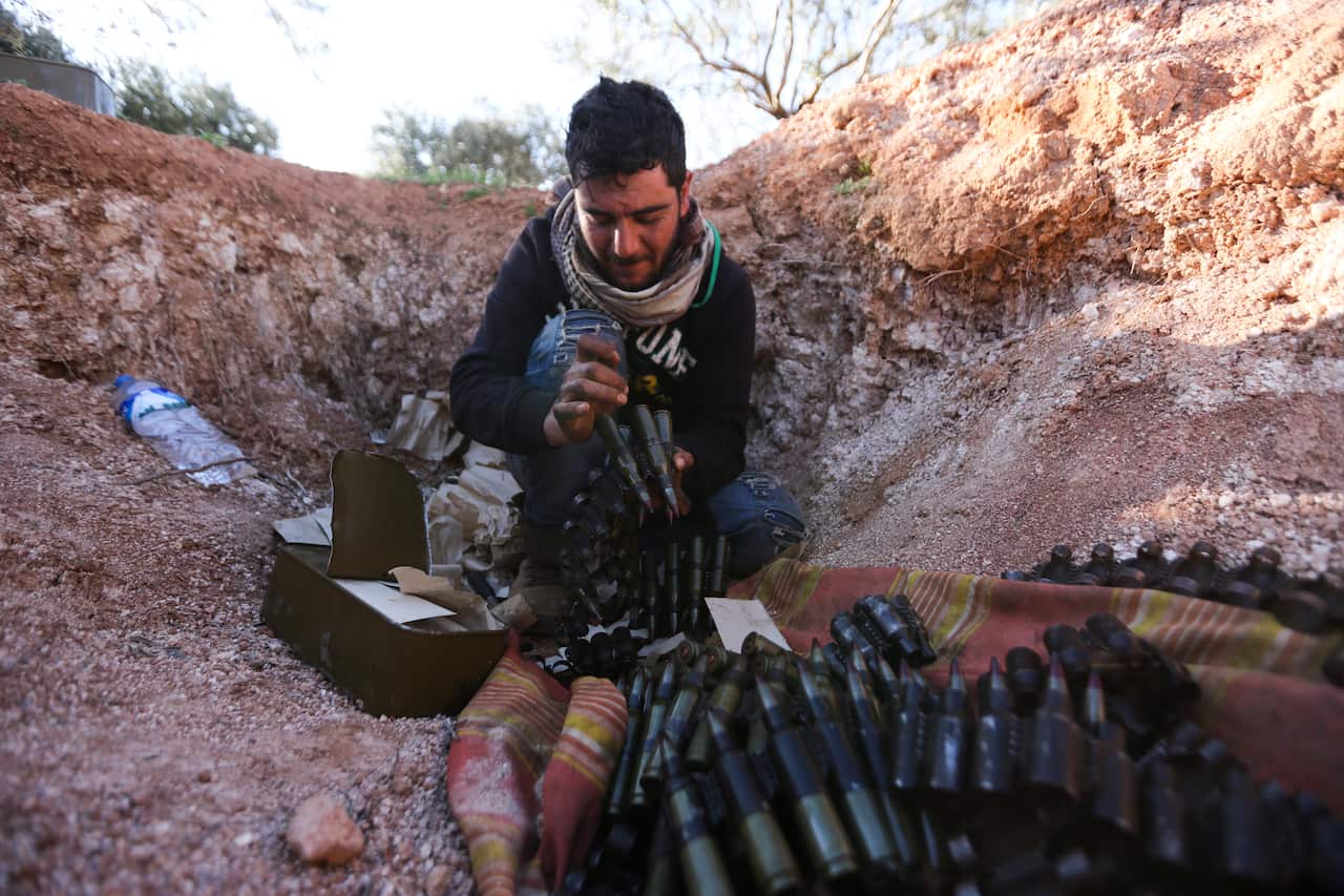Turkish backed Syrian fighter loads ammunition at a frontline near the town of Saraqib in Idlib province, Syria. 