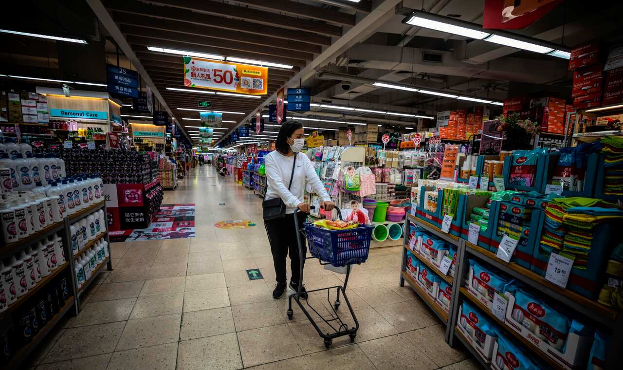 A woman wearing a protective face mask walks inside a store in Guangzhou, Guangdong province, China.