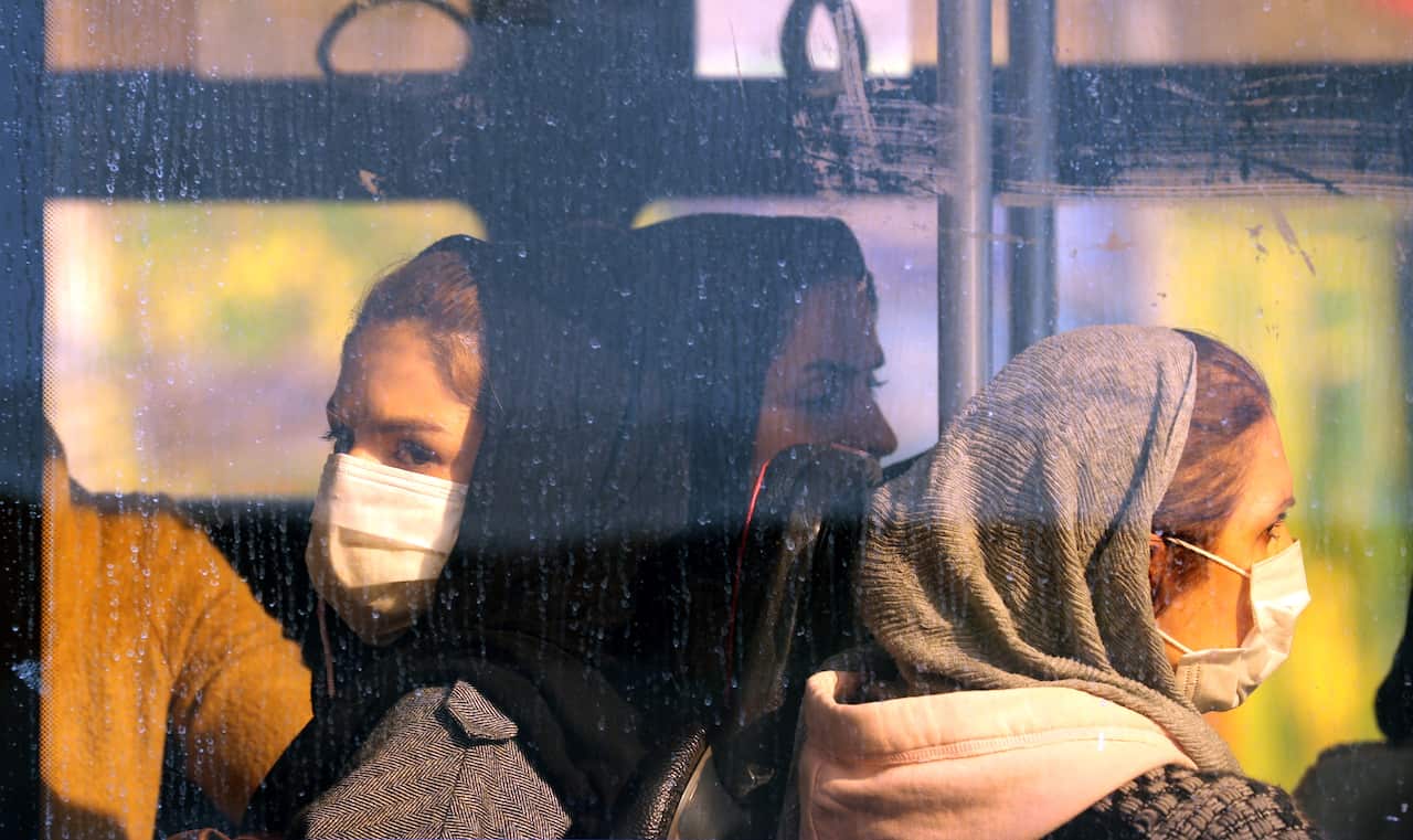 Iranian women wearing face masks sit inside a bus, in Tehran, Iran, 29 February 2020. 