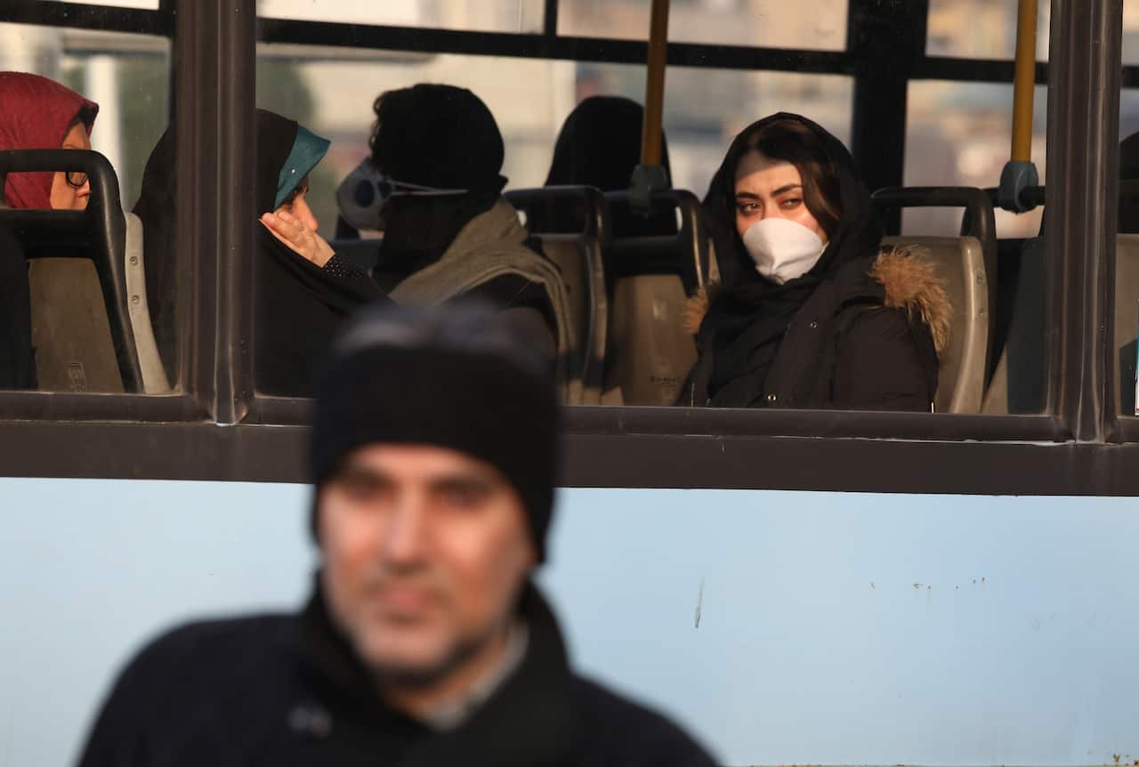 Wearing a face mask, a woman travels on a public bus at a square in western Tehran, Iran, Saturday, 29 February, 2020. 
