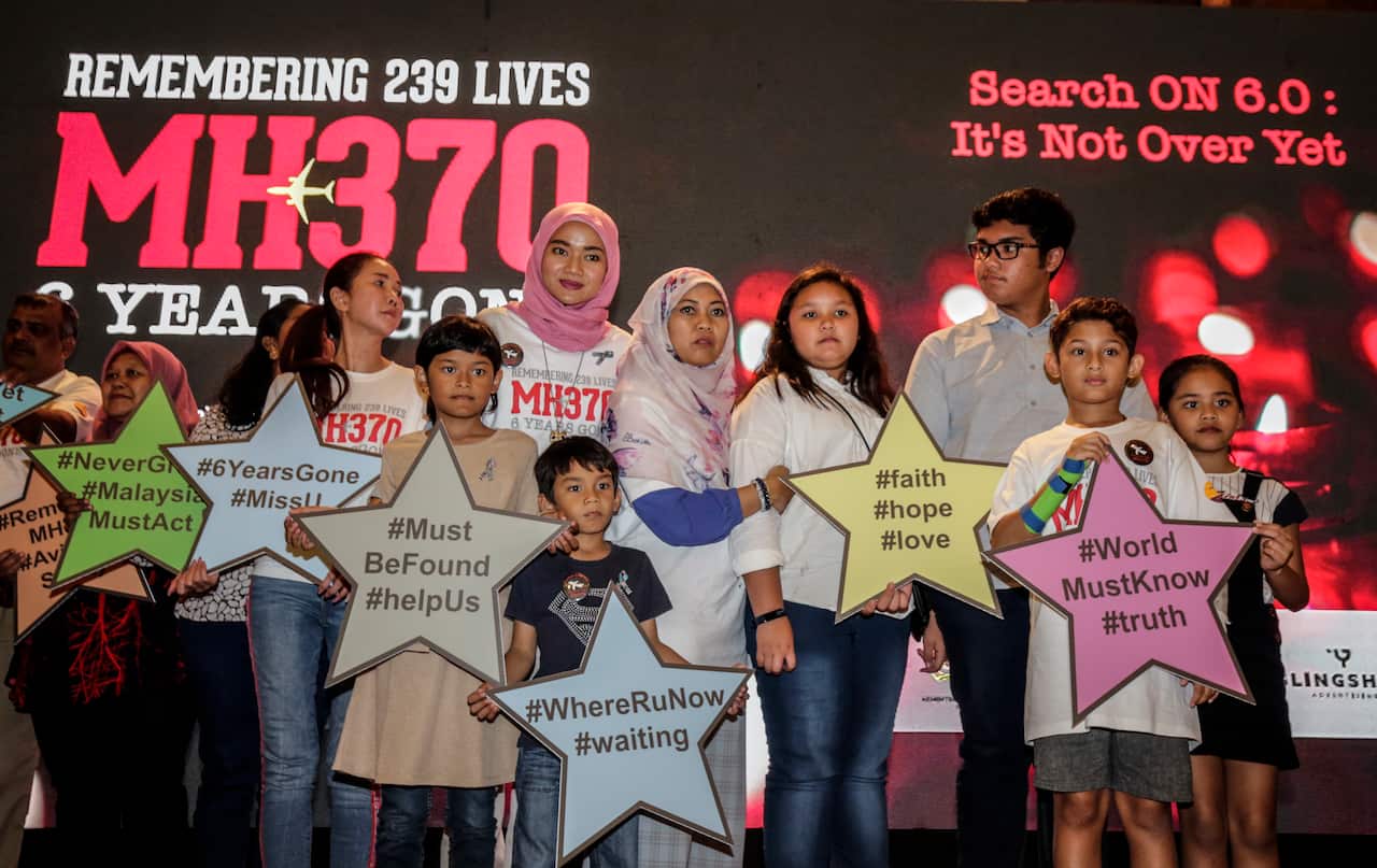Relatives of missing MH370 passengers pose on a stage for a 'namimg the star' event during the remembrance ceremony to mark the sixth anniversary of the Malaysian Airlines flight MH370 plane's disappearance