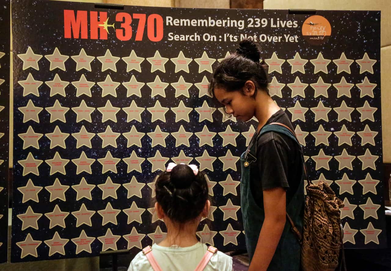 Relatives of missing MH370 passengers look at the name list during the remembrance ceremony to mark the sixth anniversary.