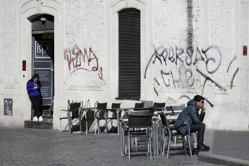 A man sits at a table in Largo Argentina square amid growing concern about the spread of a new coronavirus in Rome Saturday, 7 March.