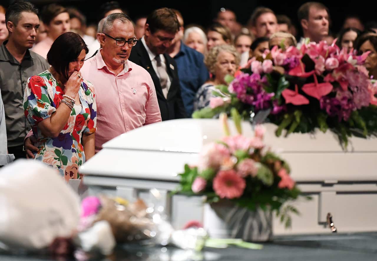 Hannah Clarke and her three children's remains are being laid to rest in a single white coffin, adorned with pink flowers.
