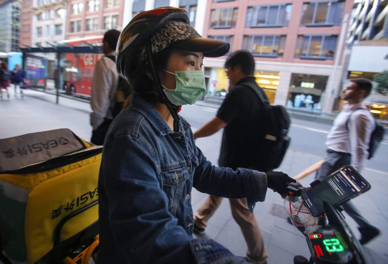 A food delivery rider wears a face mask in the CBD of Sydney.