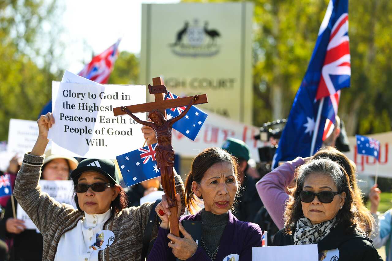 Supporters of George Pell pray outside the High Court of Australia in Canberra,.