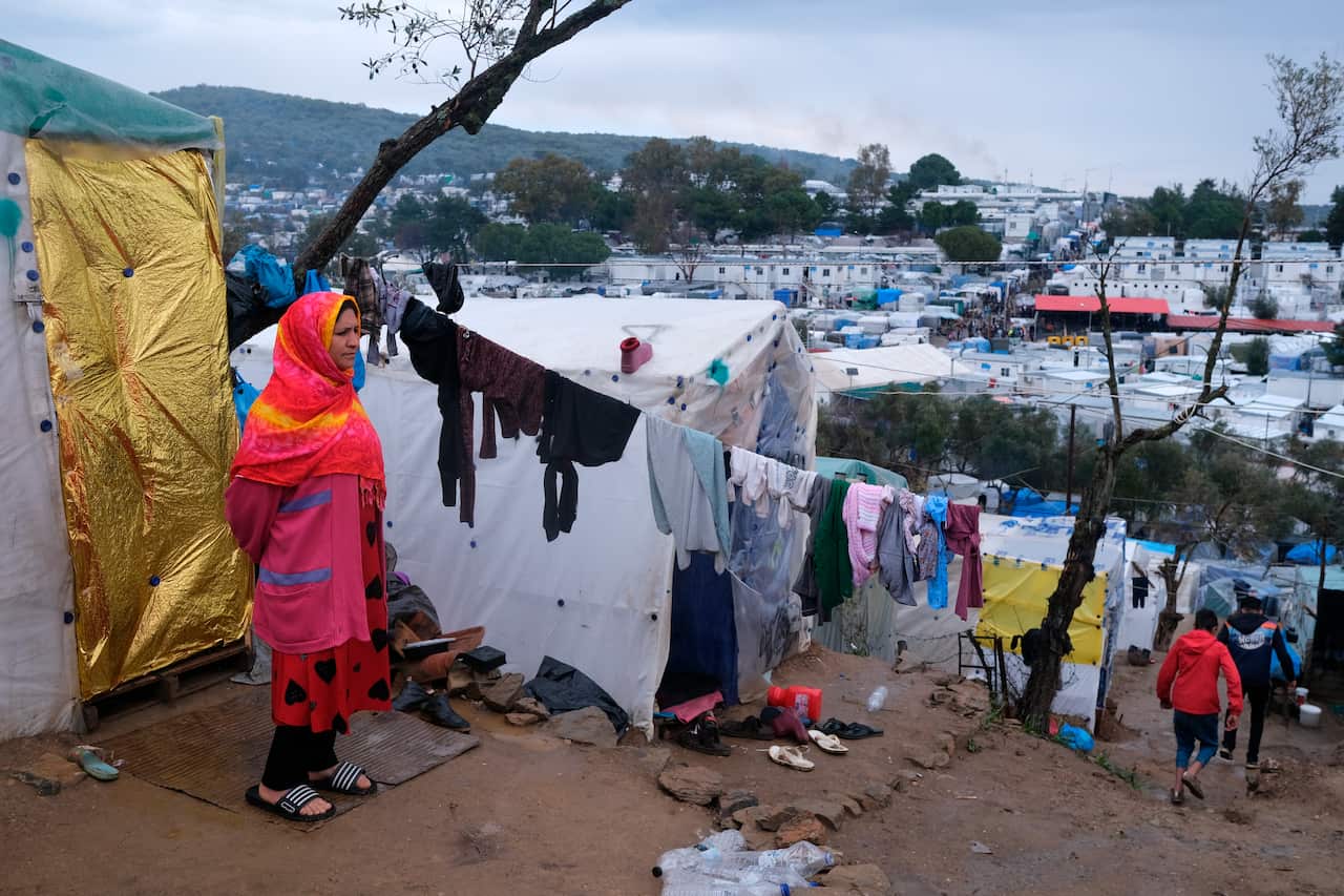 A migrant stands next to their makeshift tent outside the perimeter of the overcrowded Moria refugee camp on the northeastern Aegean island of Lesbos.