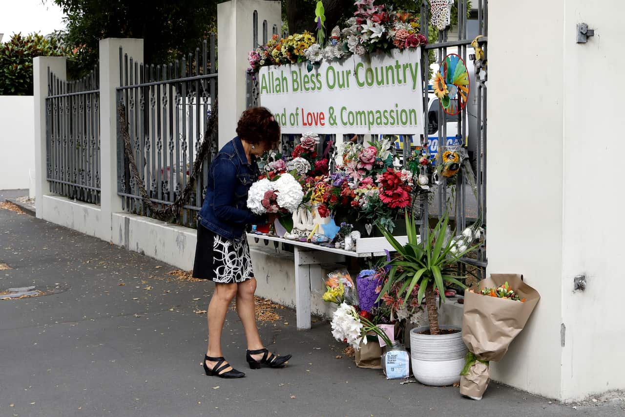 A woman prepares to place flowers at the Al Noor mosque in Christchurch