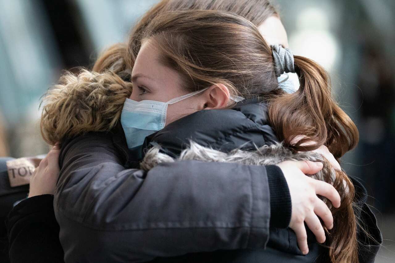 Passengers embrace after arriving on a flight from Europe at Logan International Airport in Boston, Friday, 13 March, 2020. 