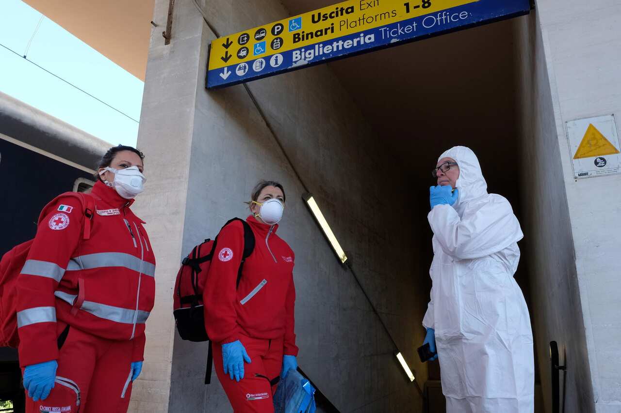 Personnel checked for passengers arriving on the Intercity Night train from Milan during the emergency lockdown.