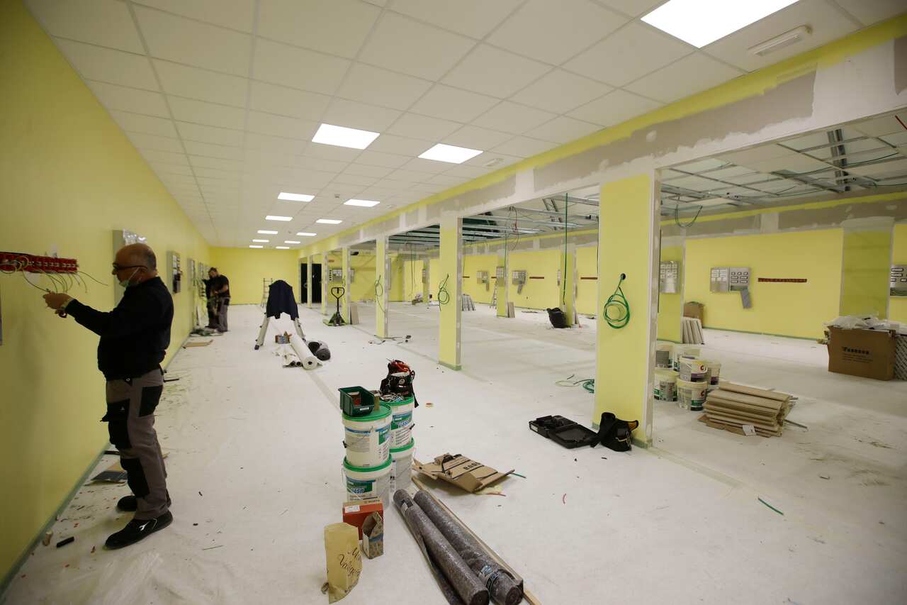 Workers operate to convert the university sports field into a new intensive care unit in Milan, Italy, Sunday