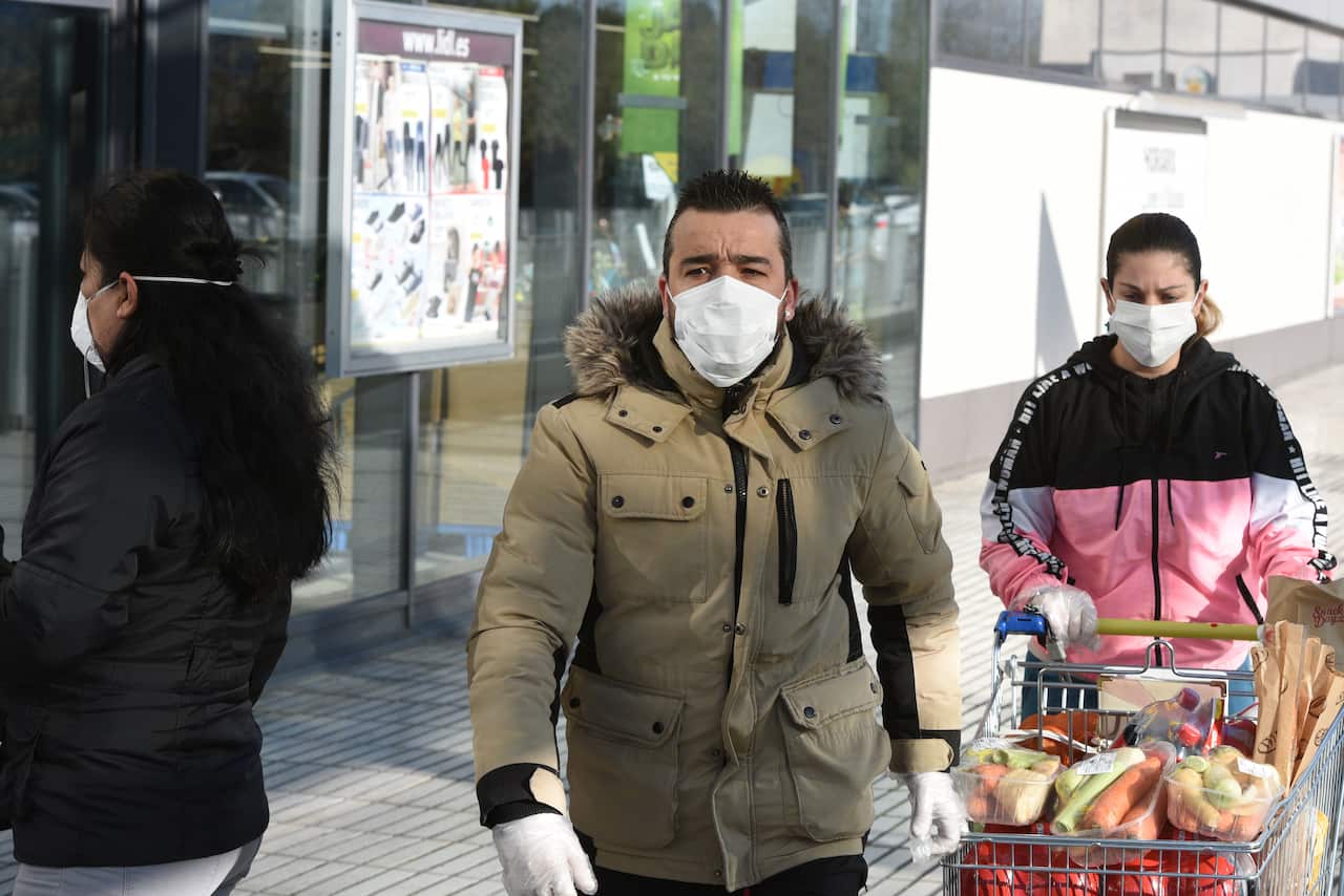 A couple wearing face masks as a precaution against the spread of Coronavirus at a supermarket in Madrid.