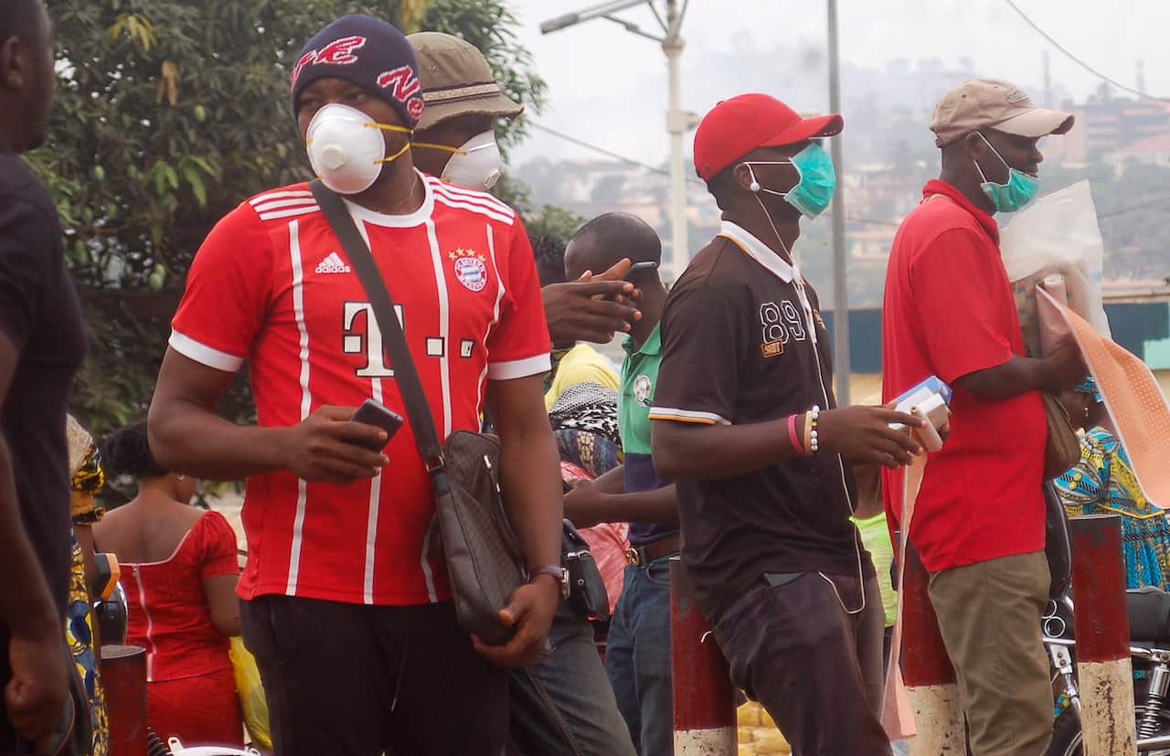 Hawkers wear face masks in Yaounde, Cameroon 18 March 2020. 