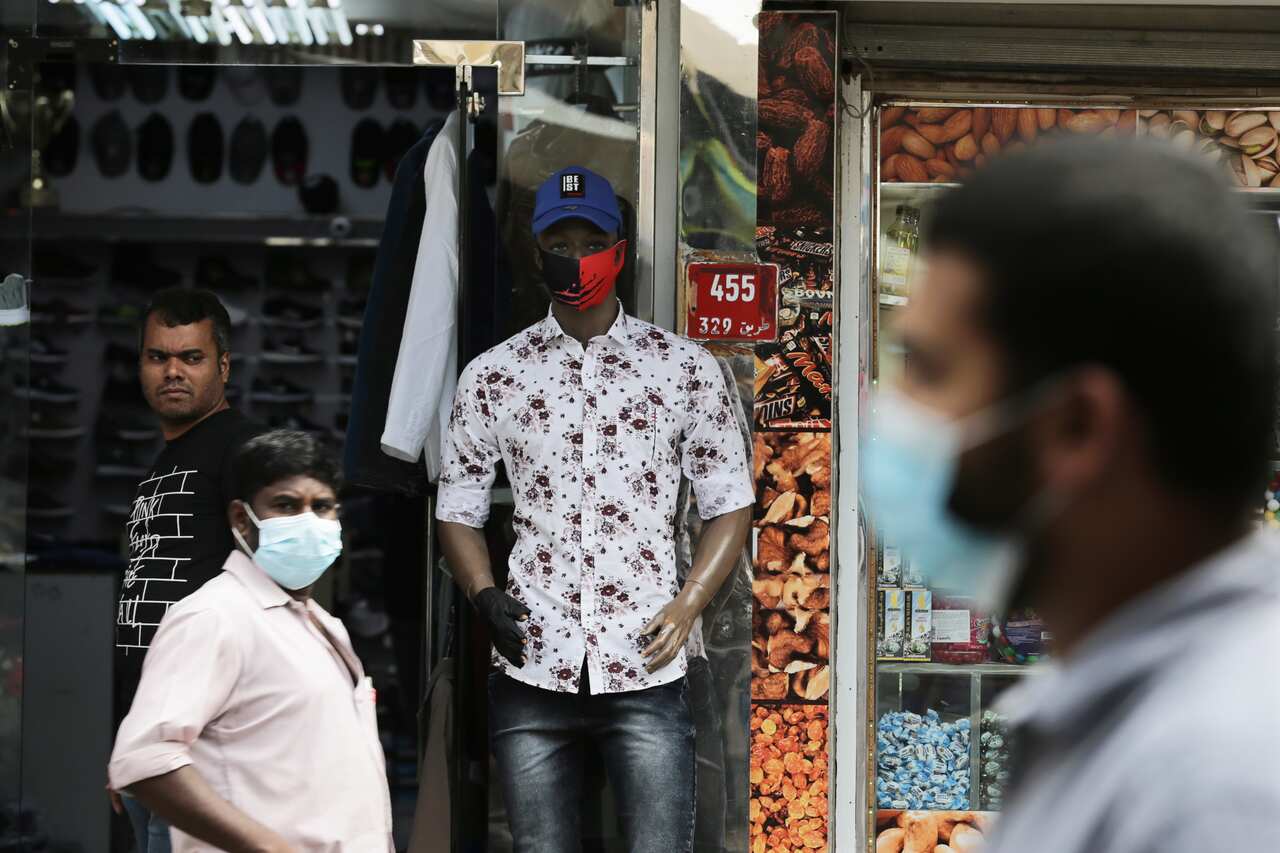 People wear protective face masks in a street of Manama, Bahrain.