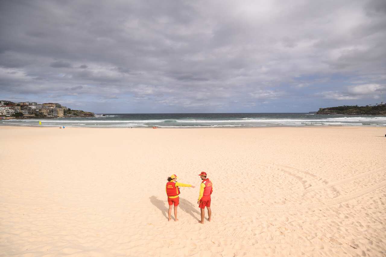Surf lifesavers on an empty Bondi Beach following its closure in Sydney, Saturday, March 21, 2020.