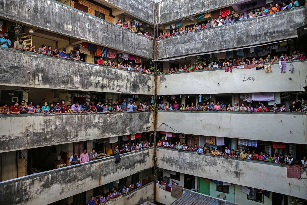Indian people bang utensils and clap from the balconies of a residential building in Mumbai, India, 