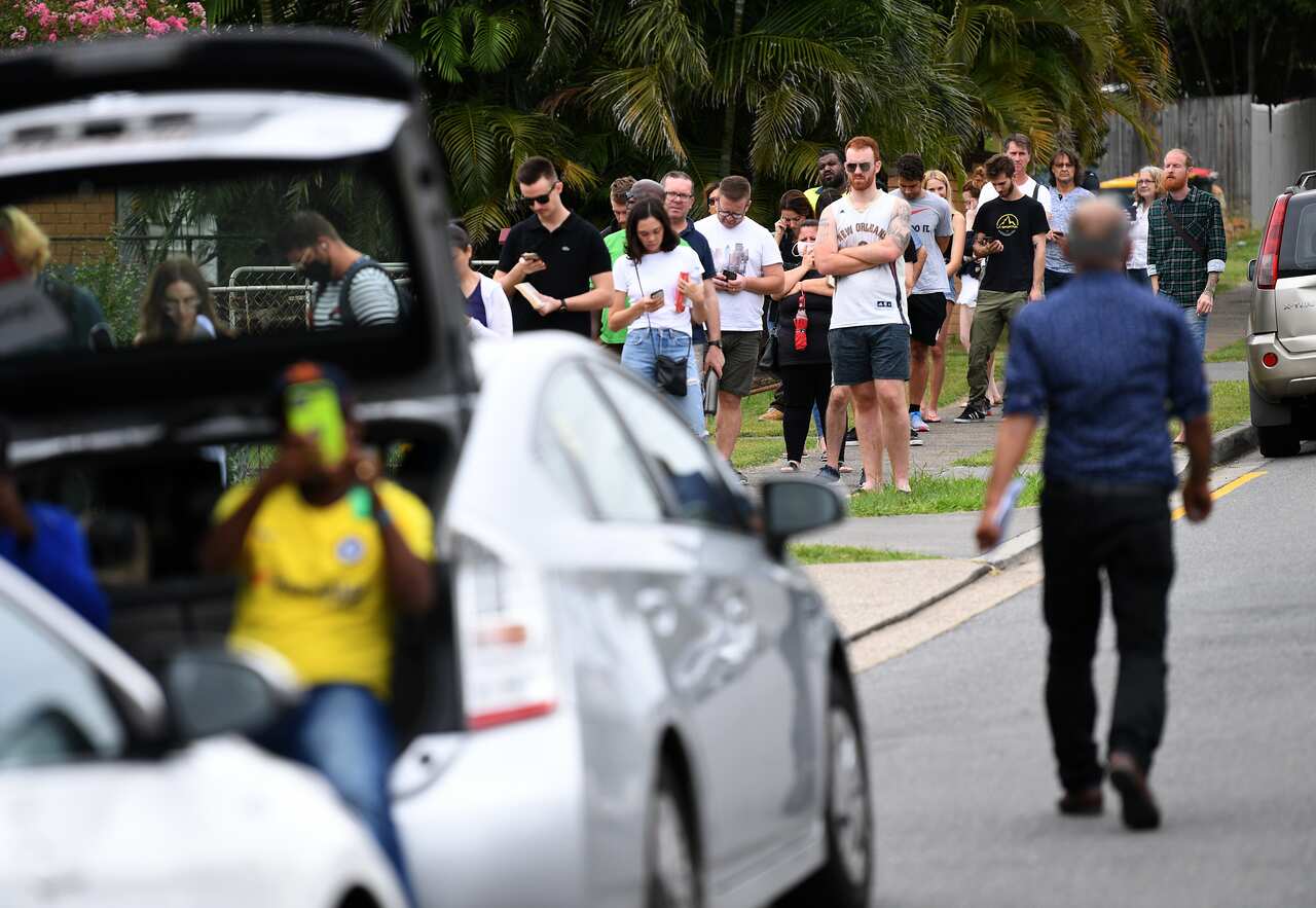 People are seen in a long queue outside a Centrelink office in Brisbane.