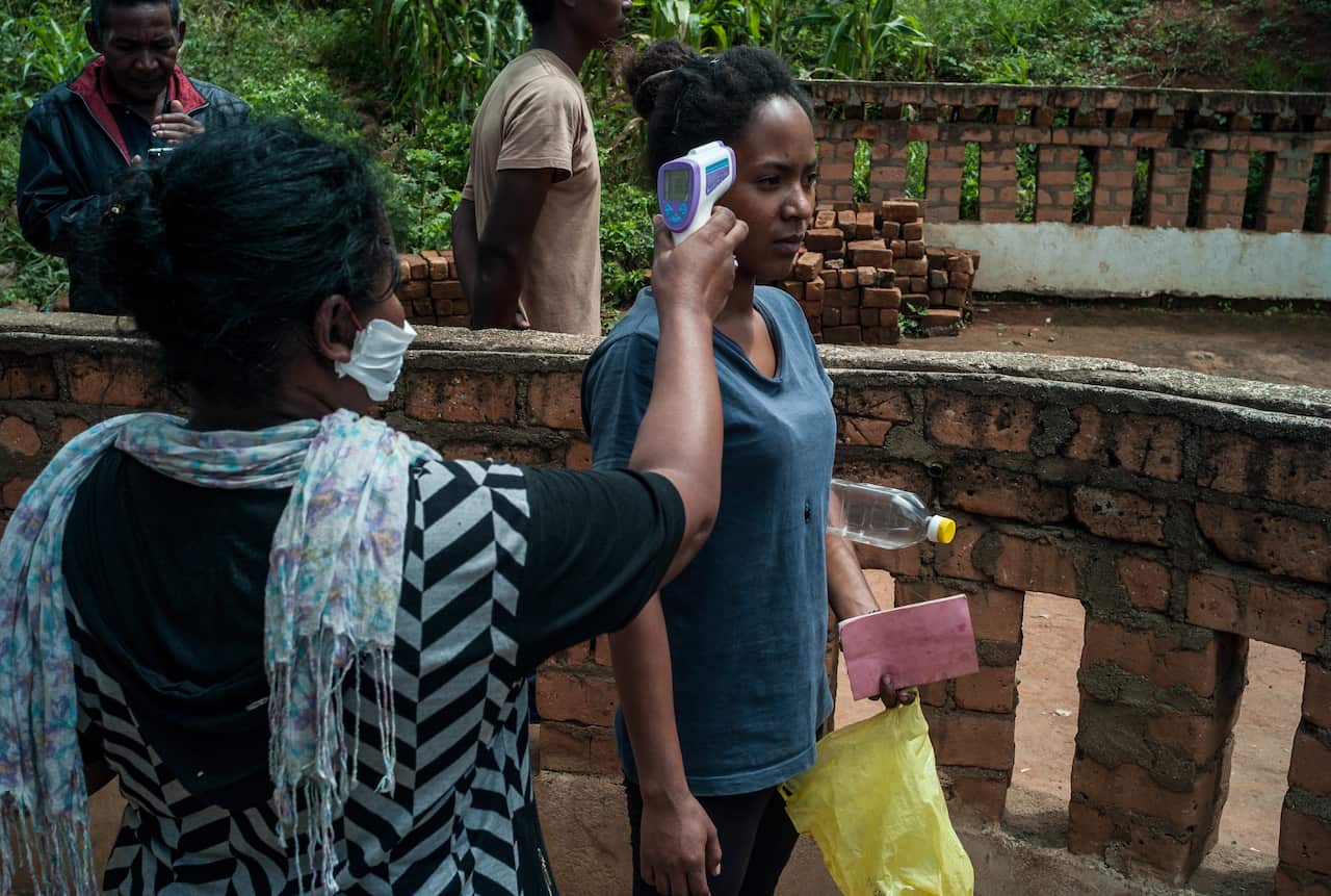 A member of the public has her temperature is taken in Antananarivo, Madagascar.