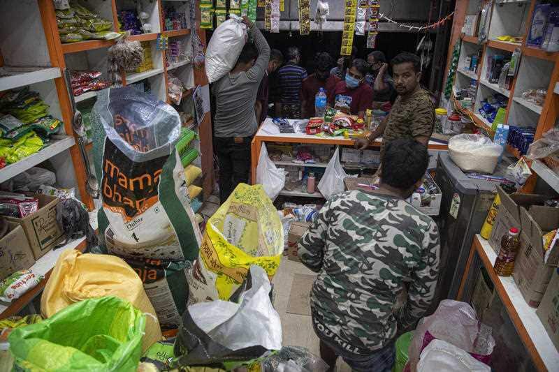 Indians buy essential commodities in a grocery shop in Gauhati, India.
