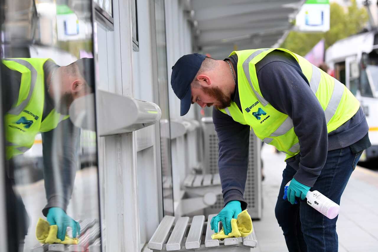 A Melbourne City Council worker cleans a tram station as part of an increased coronavirus cleaning regimen.                                                     